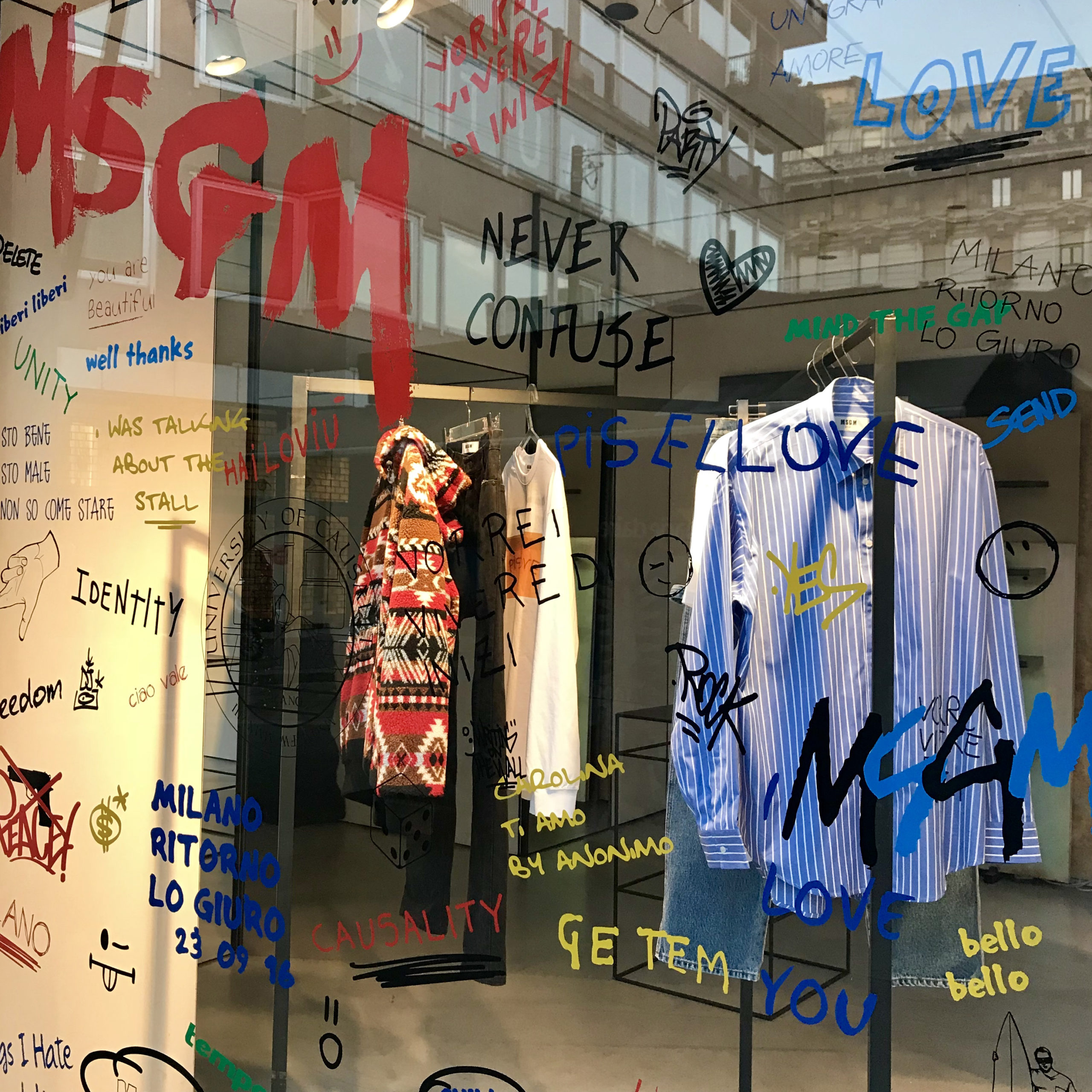 MSGM Milano window by Christian Rizzi - Sticker writing, glass and striped shirt